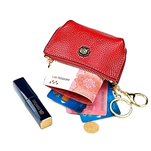 Detail of red leather coin purse featuring a golden rose relief and metal key ring