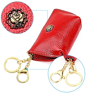 Macro detail of red litchi grain leather coin purse with golden rose logo and key ring