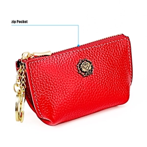 Detail of red leather coin purse with embossed bronze rose and functional gold zip pocket