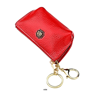 Detail of red pebbled leather key pouch with a bronze rose emblem and golden hardware