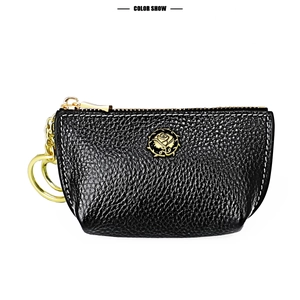 Detail of black pebbled leather coin purse with golden rose emblem and metal keychain