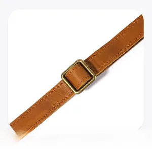 Detail of adjustable crazy horse leather shoulder strap with antique brass buckle
