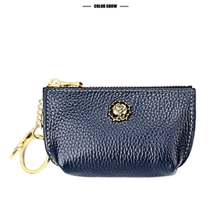 Detail of dark blue leather coin purse with golden rose emblem and premium stitching