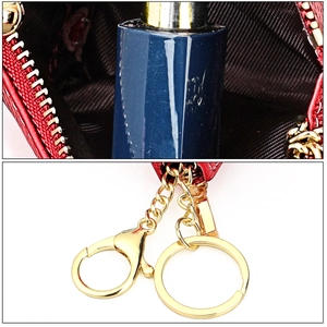 Detail of red leather coin purse featuring a gold zipper, lobster clasp, and key ring