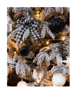 Detail von Weihnachtsbaumschmuck mit schwarz-weißem Karomuster und Holzanhängern