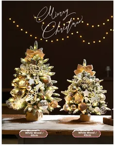 Close-up of snowy artificial mini Christmas trees with warm LED lights and festive ornaments