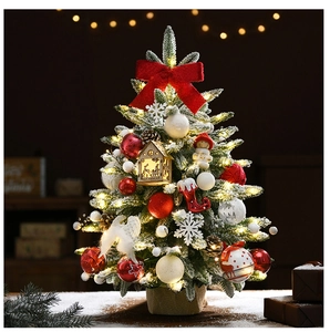 Mini Christmas tree with warm LED lights, snow flocking and red ornaments on burlap base