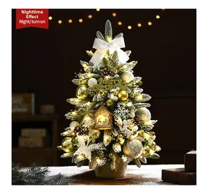 Miniature snow-flocked Christmas tree with warm LED lights and golden ornaments