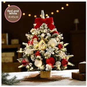 Detail of 45cm mini snowy Christmas tree with red bows, ornaments and warm lit cabin