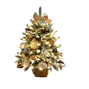 Tabletop snowy Christmas tree with warm LED lights and pine cone ornaments on white background