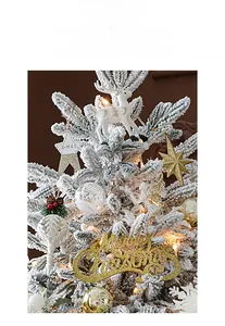 Detail of white reindeer and gold Merry Christmas ornaments on flocked snowy pine branches