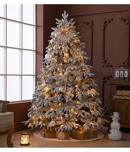 Detail of flocked Christmas tree with warm LED lights, ribbons and rustic ornaments
