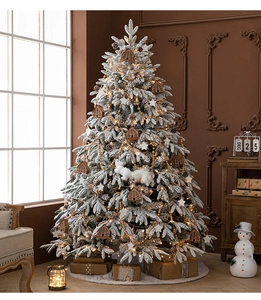 Close-up of snow-flocked Christmas tree with warm lights and festive decorations