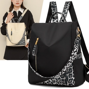 Détail du sac à dos en nylon imperméable avec fermetures éclair dorées et sangles léopard