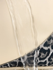 Vue macro du tissu Oxford imperméable montrant des gouttes d'eau sur beige et motif léopard