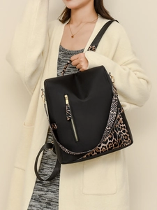 Détail du sac à dos en nylon noir avec bretelles léopard élégantes et détails dorés