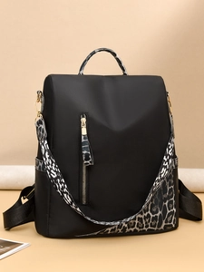 Détail du sac à dos en nylon noir avec bretelles léopard et fermeture éclair dorée