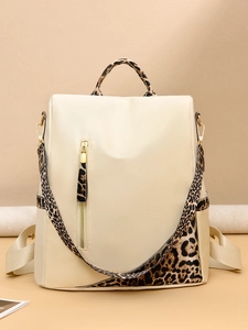 Détail du sac à dos beige en tissu Oxford avec bretelles léopard et fermetures dorées