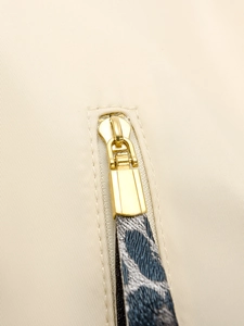 Détail d'une fermeture éclair dorée sur sac à dos beige avec bride à motif léopard