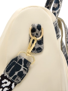 Détail du crochet en métal doré et bandoulière imprimé léopard sur sac à dos beige