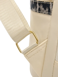 Détail de la boucle dorée et de la sangle en nylon beige sur un sac à dos léopard