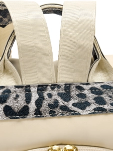 Détail d'un sac à dos en nylon beige avec bordure léopard et fermetures éclair dorées
