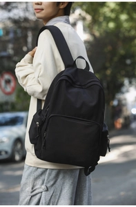 Nahaufnahme eines schwarzen minimalistischen Rucksacks mit funktionellen Reißverschlusstaschen