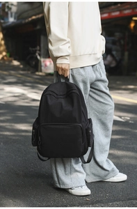 Outdoor-Lifestyle-Aufnahme eines schwarzen minimalistischen Rucksacks aus mattem Stoff