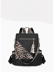 Close-up of leopard print patchwork on black backpack with matching tassel detail