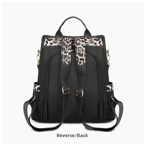 Reverse view of a black nylon backpack featuring trendy leopard print straps and gold hardware