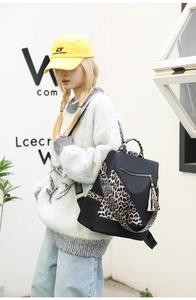 Close-up of leopard print backpack with gold zipper and stylish tassel accessory
