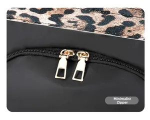 Close-up of leopard print fabric and high-quality gold dual zippers on the black backpack