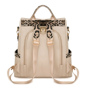 Beige leopard print backpack with water-resistant fabric and gold hardware details