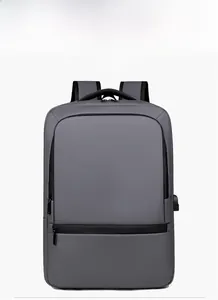 Detail view of dark grey business backpack featuring a built-in USB charging port and zipper