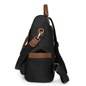 Black large capacity student backpack with brown leather trim shown from a side view angle