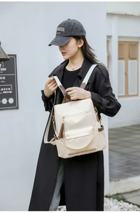 Detail of stylish white backpack with brown leather tassels and waterproof fabric texture