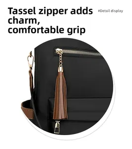 Close-up of black backpack featuring a leather tassel zipper and gold metal chain detail