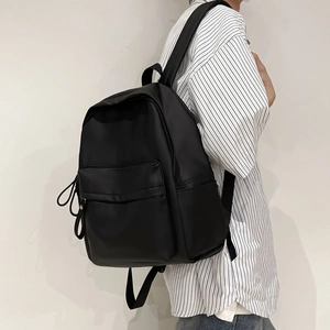 Side view of large black minimalist backpack with matte finish and long zipper pullers