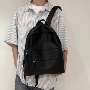 Close-up of minimalist black backpack featuring durable fabric and long zipper pullers