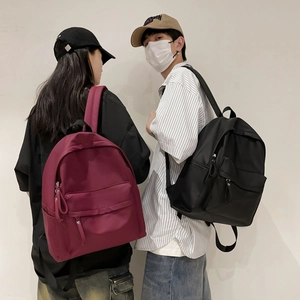 Detail showing high-capacity waterproof backpacks in dark red and black with zipper pockets