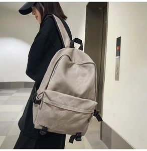 Close-up of minimalist khaki backpack featuring large compartments and side buckles
