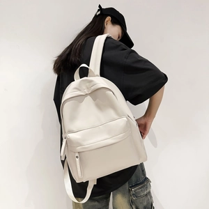 Model wearing a minimalist cream white large capacity nylon backpack for women