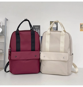 Close-up of lightweight burgundy and beige nylon backpacks with waterproof texture