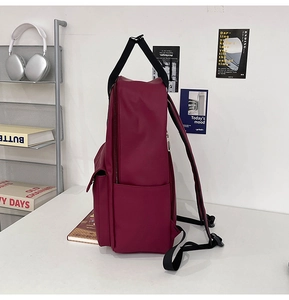 Side view of large capacity burgundy backpack with multiple pockets and durable straps