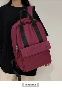 Burgundy nylon backpack showing padded shoulder straps and a vertical side zipper pocket