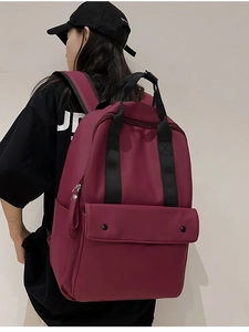 Side view of large burgundy travel backpack with adjustable straps on a model