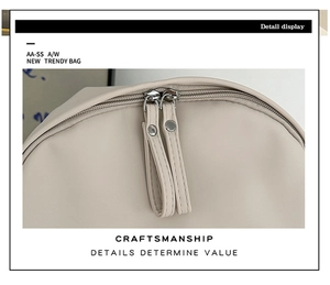 Detailed macro view of the double smooth zipper on a minimalist cream-white backpack
