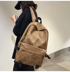 Brown vintage style backpack shown on a model with large capacity and zip compartments