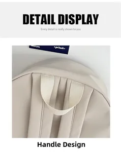 Detail showing the reinforced top handle and wide shoulder straps of beige backpack