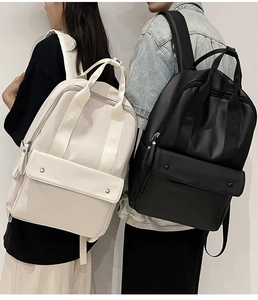 Front view of black and beige minimalist large capacity backpacks shown on a model